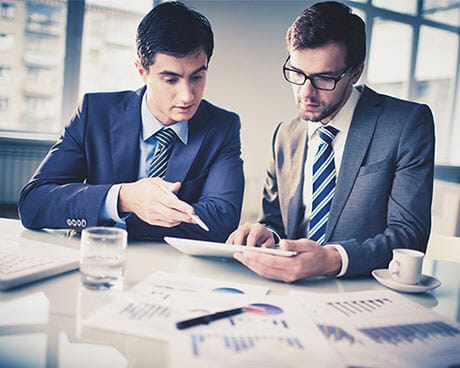 Two men reviewing investment data